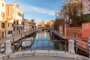 Scenic view of traditional old Venetian houses over a canal and boats, Venice, Italy