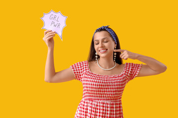 Young pin-up woman pointing at GRL PWR sign on yellow background. Women's History Month