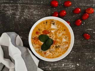 Soup in a white plate on a black background 