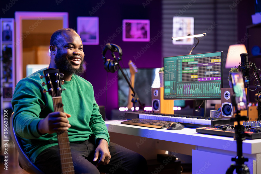 Poster musical composer hosting online guitar lessons with tutorial video on smartphone, recording himself 