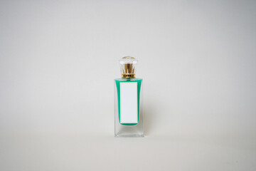 Minimalist photo of a perfume bottle with green trim, a blank white label, and a gold cap. Ideal for luxury fragrance branding, cosmetic mockups, and beauty product presentations.

