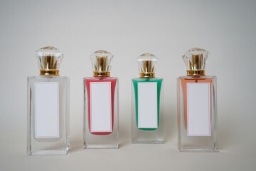 A row of four stylish perfume bottles with blank white labels and gold caps in varied pastel colors. Perfect for branding, fragrance product mockups, or luxury beauty content creation.

