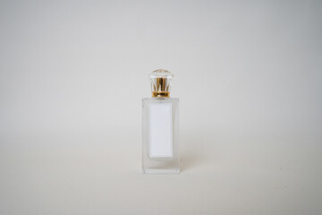 Front-facing perfume bottle with a gold cap and blank white label, set against a neutral background. Ideal for branding mockups, cosmetic product visuals, and luxury fragrance concepts.