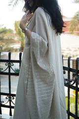 A gracefully designed beige abaya featuring intricate embroidery, reflecting timeless Saudi elegance. The soft fabric, delicate details, and neutral tones create a sophisticated and modern aesthetic.