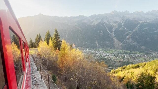 Chamonix, France - 1 November 2024: A ride on the iconic red Montenvers train in Chamonix, leading to the Alpine glacier. Breathtaking views of the mountains, the town below, and vibrant autumn trees.