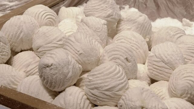 Close-up of white zephyr covered in powdered sugar, one cut in half. Delicious dessert, confectionery showcase, unhealthy eating concept.