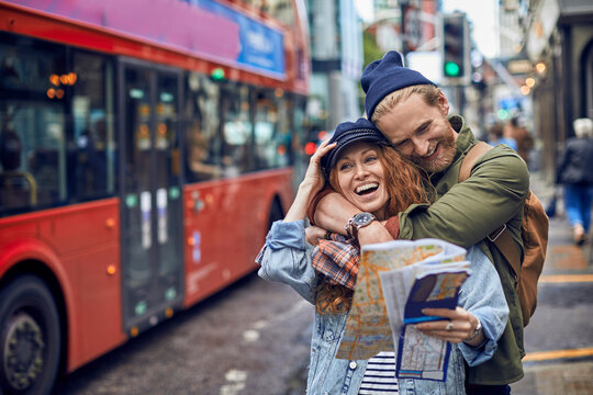 Young redhead couple smiling and exploring the city