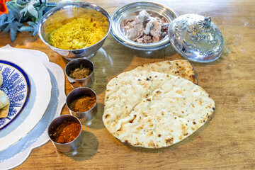 Samosas with various spices, saffron rice, naan bread and duck meat at an Indian food