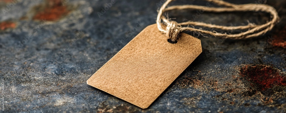 Poster Blank cardboard tag with string lying on grunge background