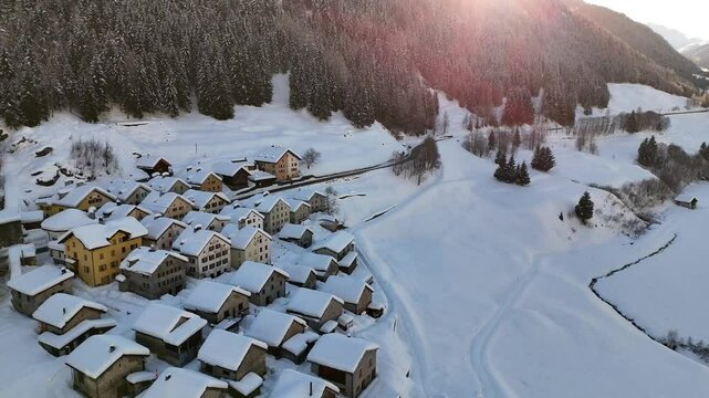 Aerial video above a small snowy village in winter in the Fontana val Bedretto Snow area