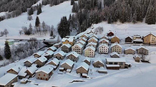 Aerial video above a small snowy village in winter in the Fontana val Bedretto Snow area