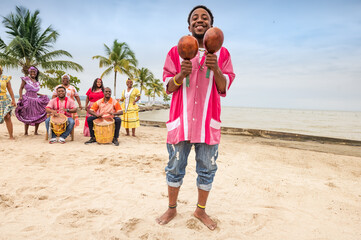 Latin man of the Garifuna ethnic group plays the maracas and enjoys the music.