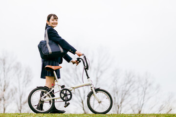 自転車を押して歩く制服姿の中学生・高校生・女子高生
