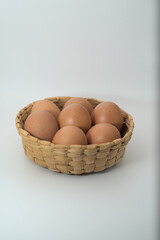 Brown eggs in a basket on a white background 