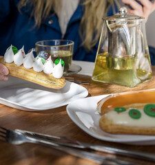 Person is holding a pastry with whipped cream on it