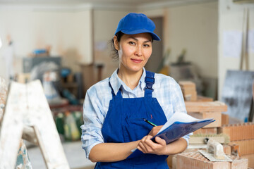 Woman foreman checks the completed construction work on the drawing