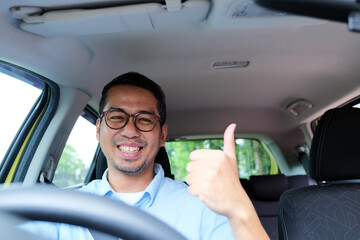 A car driver smiling happy and give thumbs up