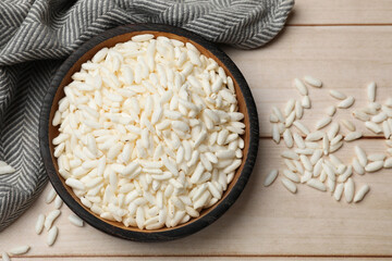 Puffed rice in bowl on white wooden table, flat lay
