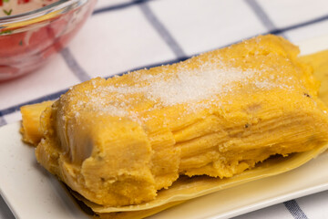 detalle de humitas en hojas con azucar, plato típico Chileno en Verano, junto a ensalada de tomate...