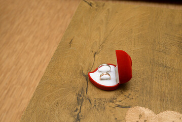 Wedding rings in a red elegant heart-shaped box with white lining inside