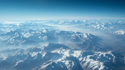 Stunning Aerial View of Snow-Capped Mountains Under Clear Sky