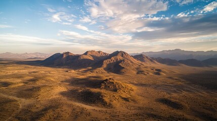 Naklejka premium Scenic Aerial View of Majestic Mountain Range Under Blue Sky