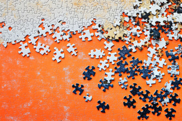 A Scattered Jigsaw Puzzle on an Orange Background Shows Incomplete Pieces