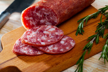 Salchichon, traditional spanish dry cured pork sausage on wooden table