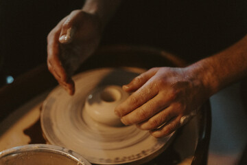 Person Working on a Clay Wheel, Shaping the Beginning of a Pot