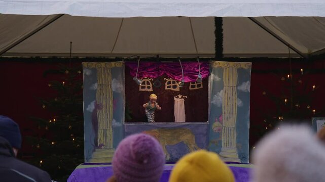 Puppet Show on Stage at a Christmas Market with Captivated Audience
