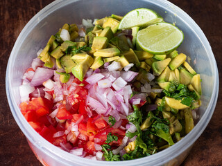chopped fresh tomato, avocado, shallot, coriander and lime in food container