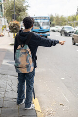 A student standing at the bus stop, signaling to stop the bus, ideal for themes like student life,...