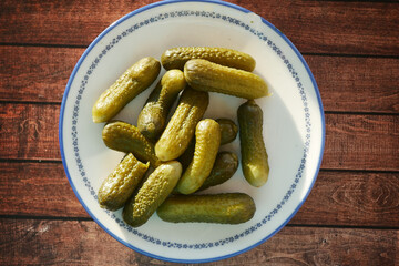 Freshly prepared pickles served in a bowl on wooden table