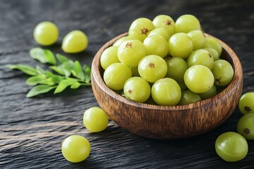 Indian gooseberry or Amla in a wooden bowl on black background