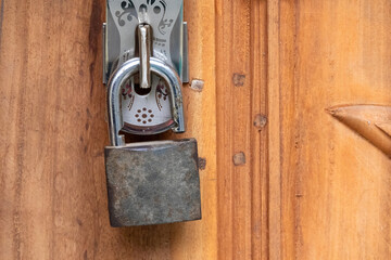 Close-up of an old, unlocked door lock on a wooden door.
