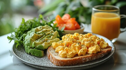Breakfast plate featuring scrambled eggs on toast with avocado, salad, and orange juice