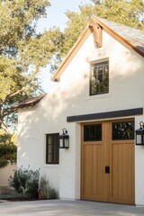 Charming modern farmhouse style building featuring wooden doors and large windows surrounded by lush greenery in a sunny outdoor setting