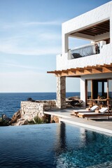 Luxurious oceanfront villa with modern architecture offers stunning sea views and relaxation in a serene coastal setting during a bright sunny day