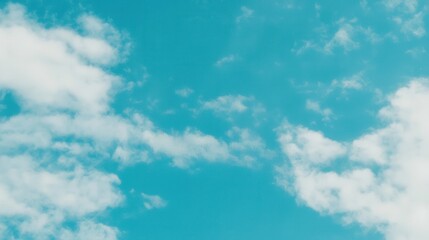 Fototapeta premium A serene blue sky filled with fluffy white clouds, creating a peaceful and uplifting atmosphere.