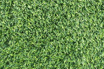 close-up of a lush, green artificial turf. The synthetic blades of grass are perfectly aligned and...