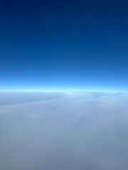 飛行機の窓から広がる雲海と青い空 | Expansive Sea of Clouds and Blue Sky from an Airplane Window