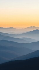 Fototapeta premium Serene Sunrise Over Misty Mountain Ridges Captured in Vertical Frame for Tranquil Nature Art