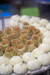 Close-up of steaming steamed buns and siomai in breakfast shop