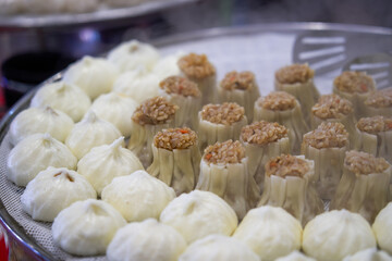 Close-up of steaming steamed buns and siomai in breakfast shop