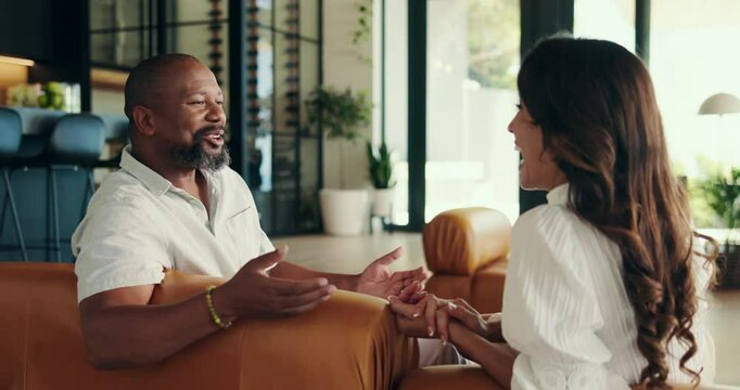 Laugh, connection and people on first date with relax, joke and bonding together in home. Happy, comic and interracial couple talking with comedy for fun on sofa in living room at apartment.