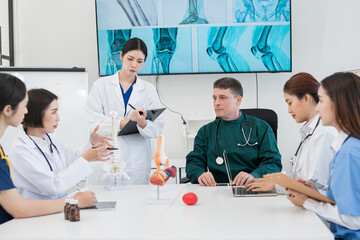 Male and female doctors are having a meeting in a hospital room.