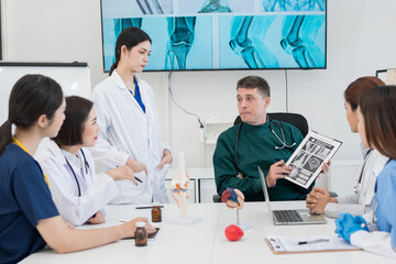 Male and female doctors are having a meeting in a hospital room.