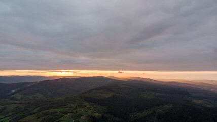 Majestic Mountains, Dense Forest, And Dramatic Clouds Illuminated By A Stunning Sunset. Aerial View Capturing The Breathtaking Beauty Of Nature From A Bird’s-Eye Perspective.	
