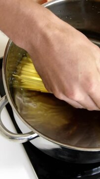 Man cooking pasta in saucepan