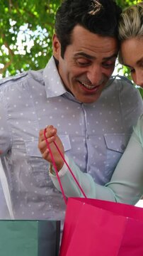 Surprised couple looking into shopping bag on a sunny day